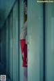 A woman in a red bathing suit standing in a hallway.