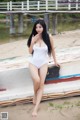 A woman in a white bathing suit sitting on a boat.