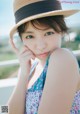 A young woman wearing a straw hat posing for a picture.