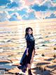 A woman standing on a beach next to the ocean.