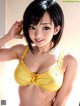 A woman in a yellow bra and panties posing for a picture.